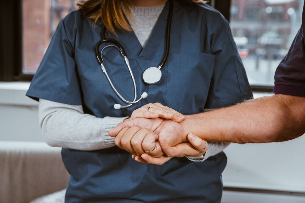 Nurse holding patients hand